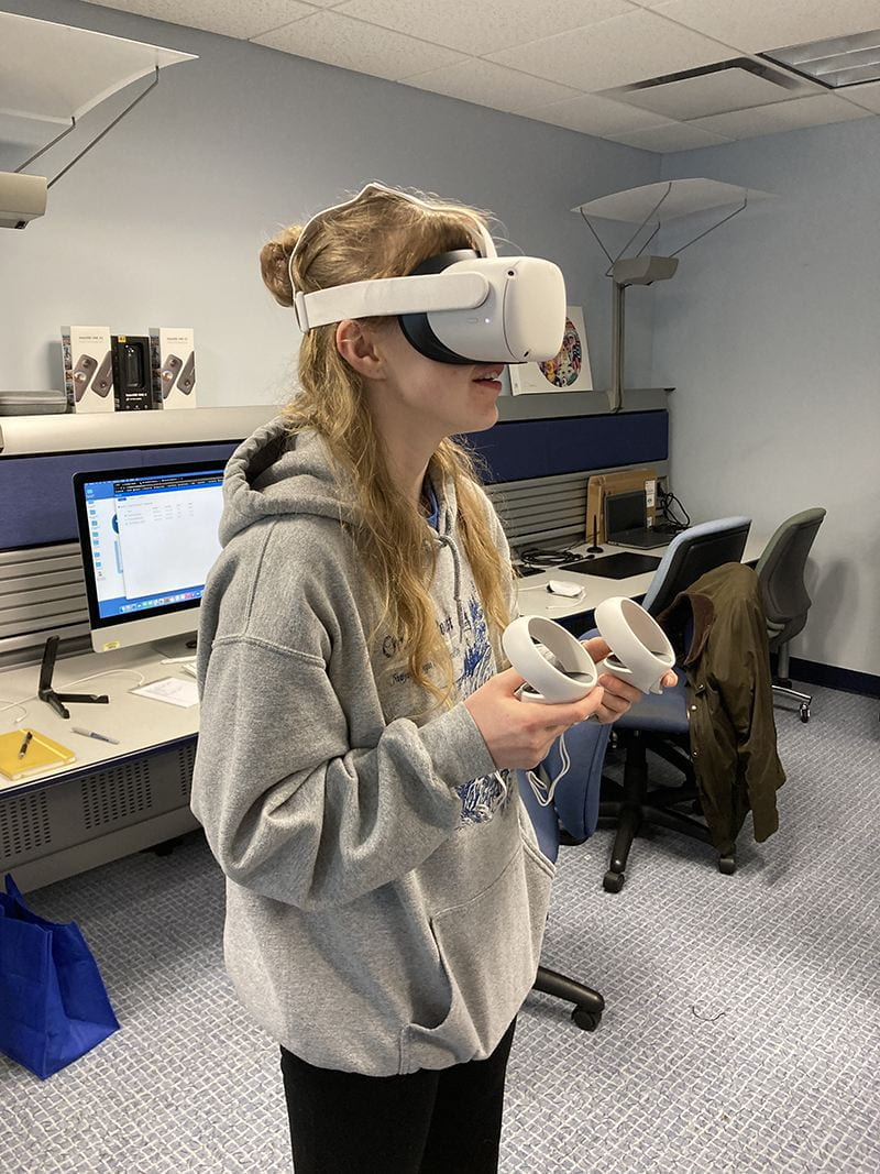 Student using VR headset and hand controllers