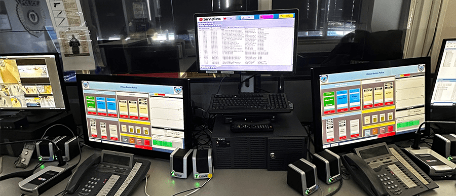A snapshot of the campus safety office reveals a high-tech command center, featuring a neatly arranged desk adorned with computers, phones, and monitors.